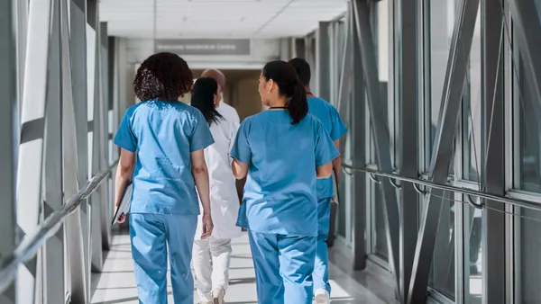 A group of medical professionals walk down the hallway together.