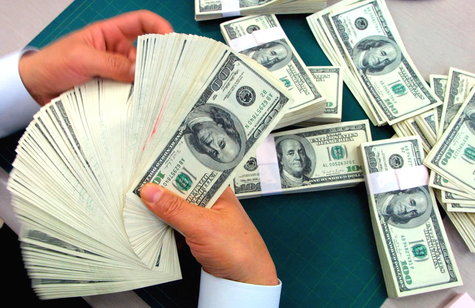 A bank employee counts U.S. dollars banknotes at the headquarters of the Korea Exchange Bank.