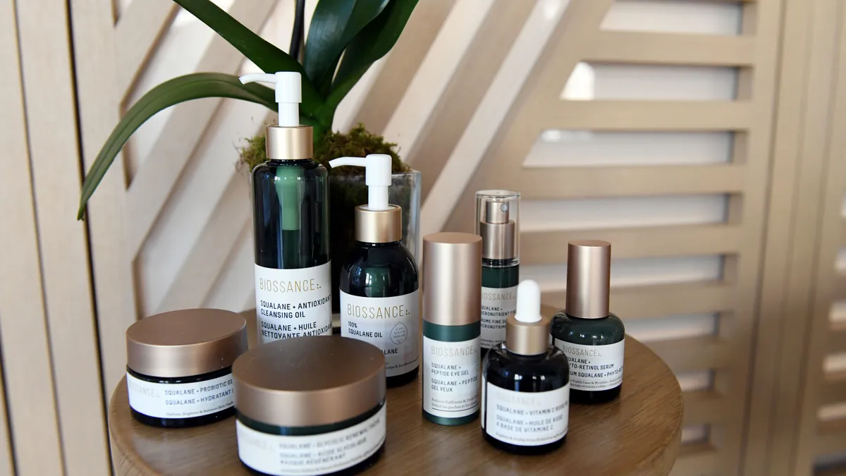 Green skincare bottles from Biossance displayed on wooden table