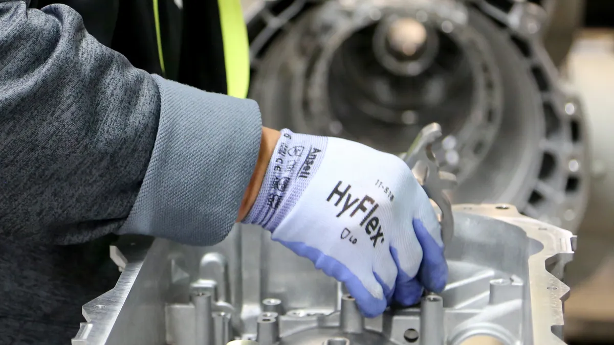 An eemployee installs a pin on an eight-speed transmission at the Kokomo Transmission Plant.