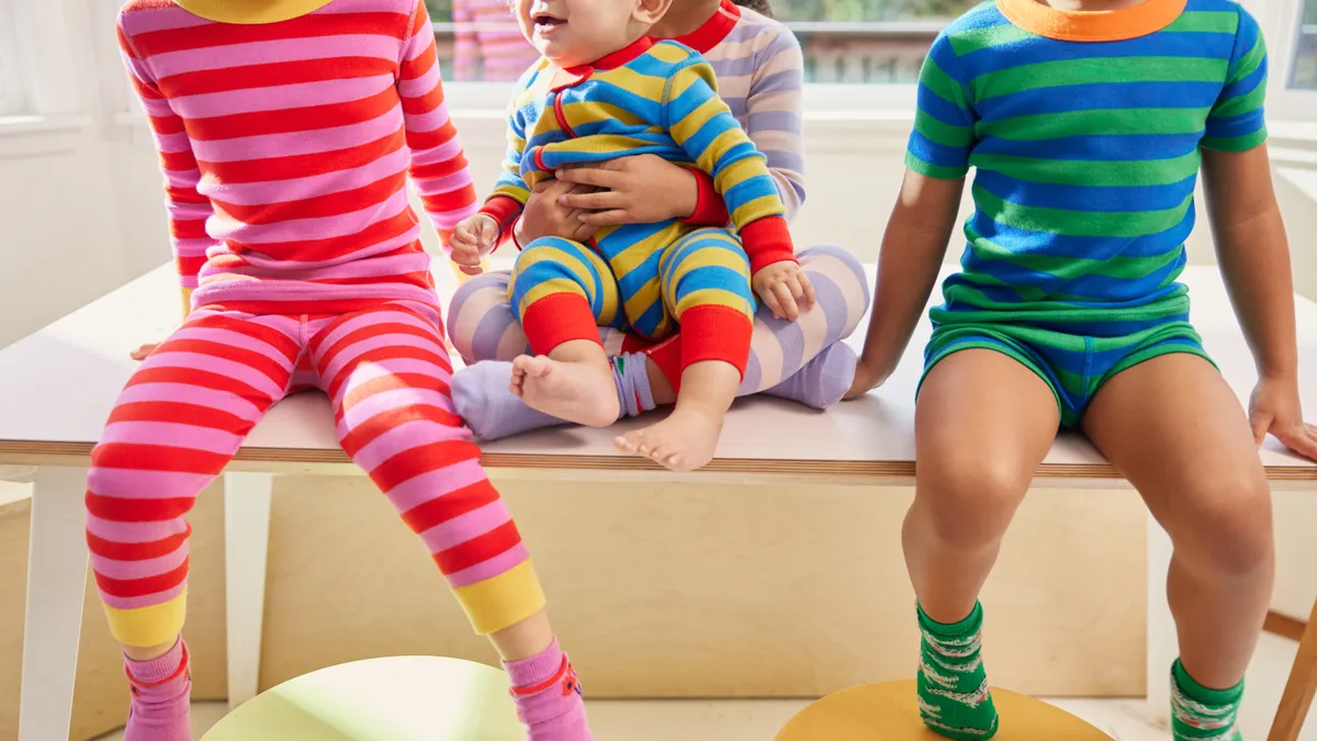 Three young children wear red and blue striped pajama sets