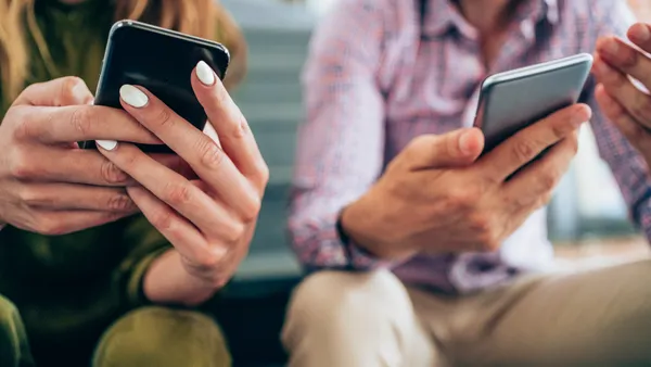 Young people sitting on the stairs and using smartphones.