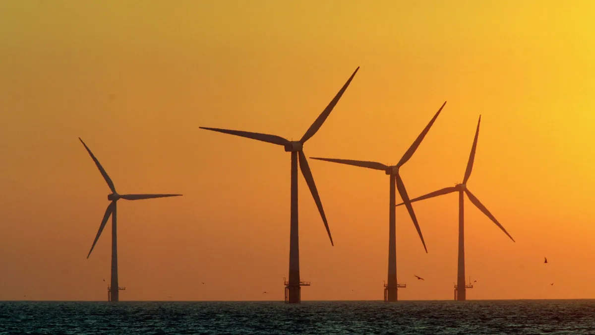 Wind turbines in the sea at sunset.