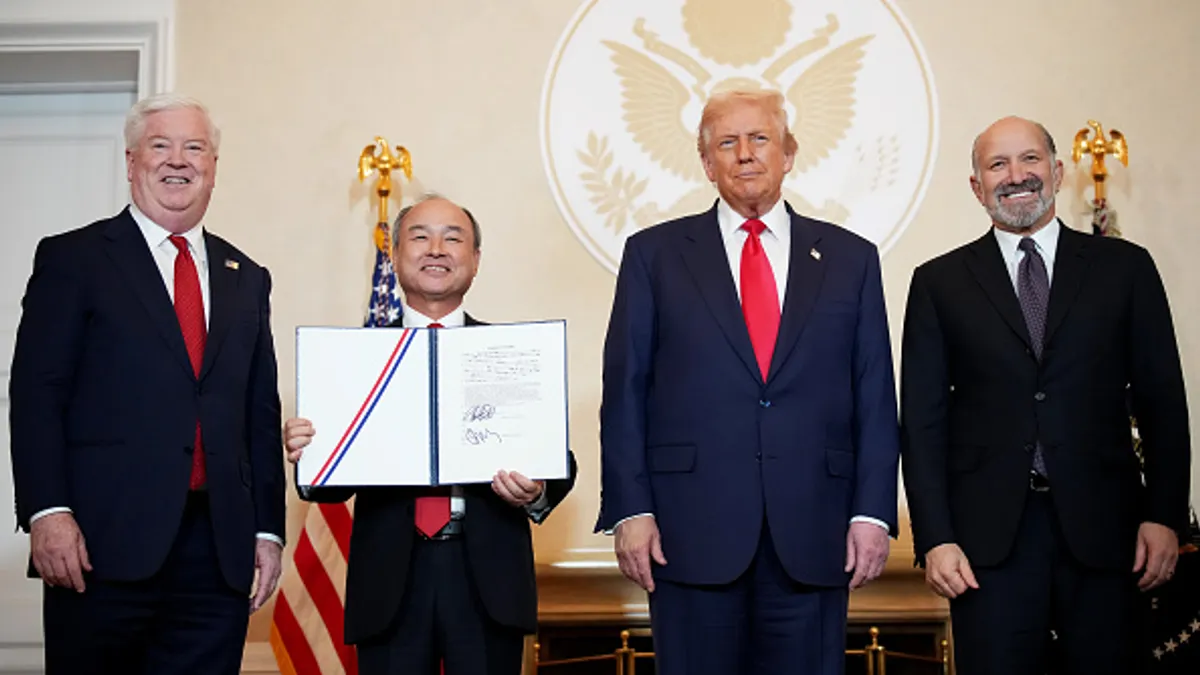 A group of four men pose for a photograph.