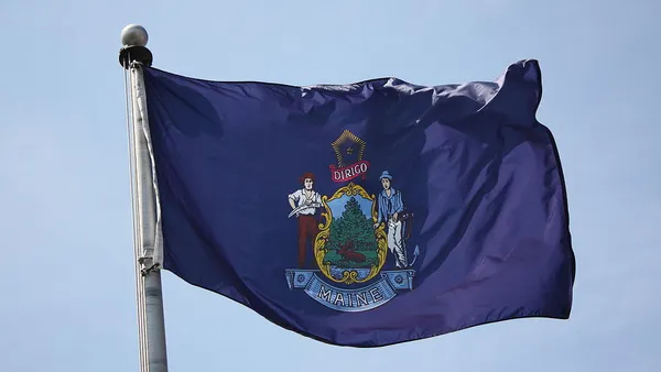 A flag with the words "Dirigo" and "Maine"