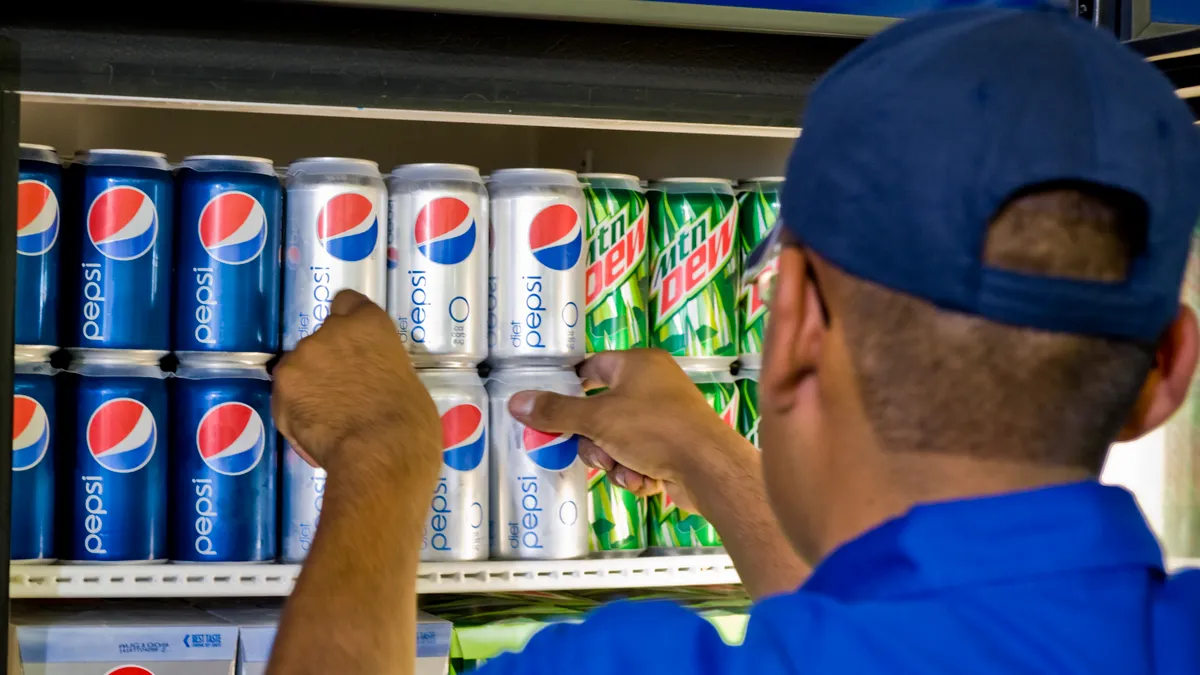 A Pepsi employee stocks a cooler with Pepsi, Diet Pepsi and Mountain Dew