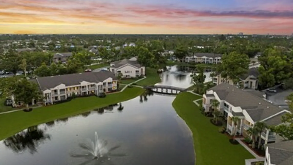 Aerial picture of a garden-style apartment community surrounding water.