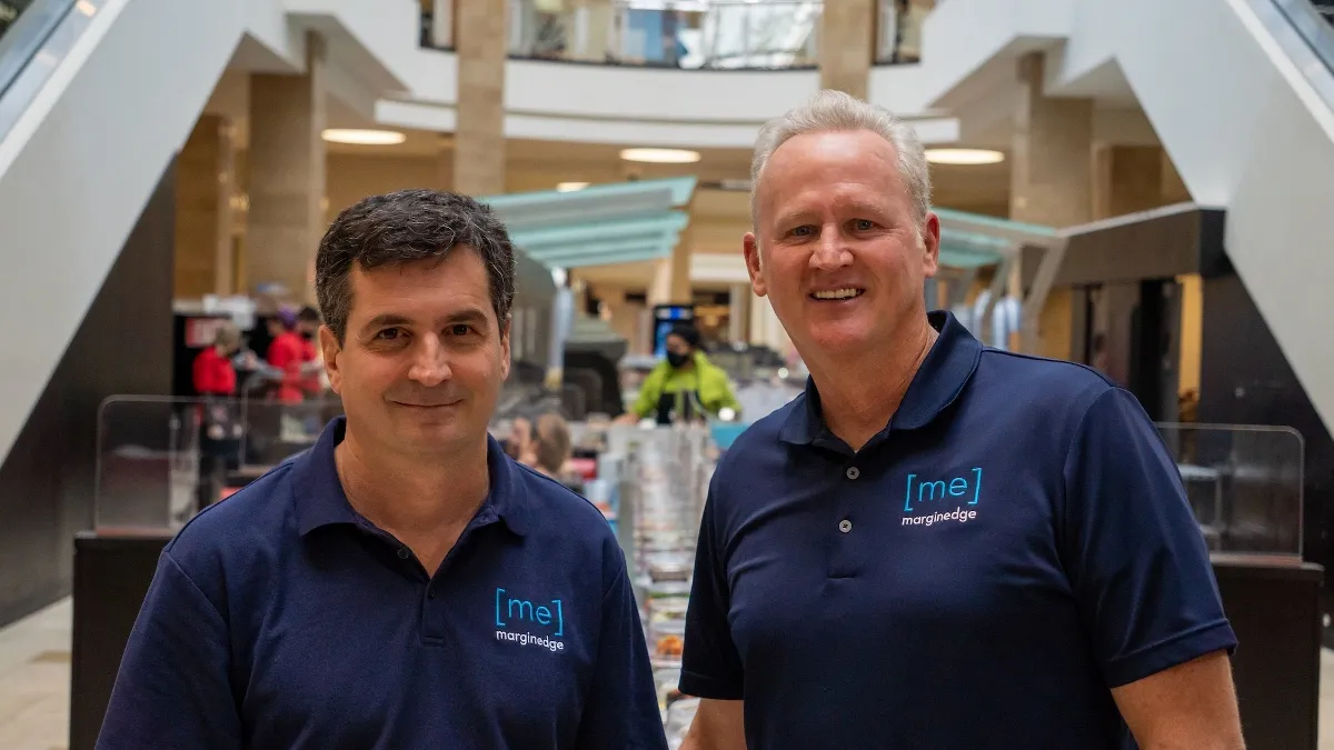 An image of two men wearing blue shirts