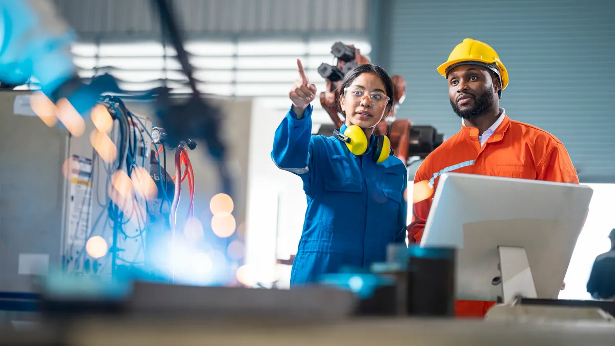 Female engineer presentation robotic welding process to her team in testing area of research and development. Production process improvement concepts.