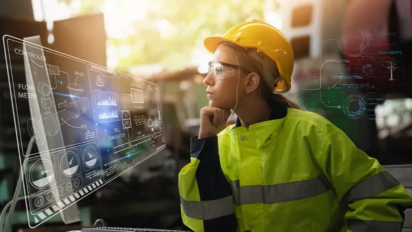 Woman looking at screen in construction uniform
