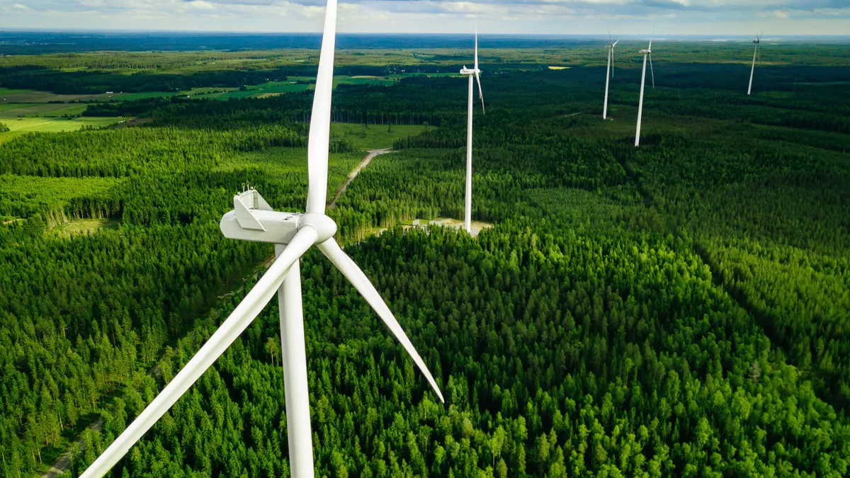 Aerial view of windmills in green summer forest in Finland