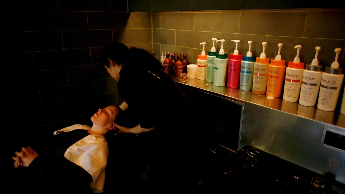 A worker colors a client's hair.