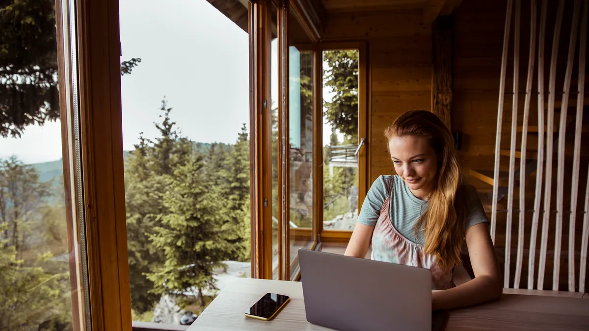 Young woman working from home using laptop computer.