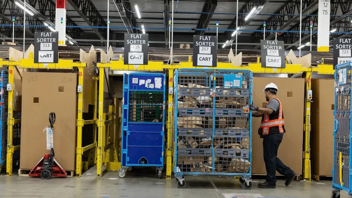 A warehouse worker pushes a large cart of packages.