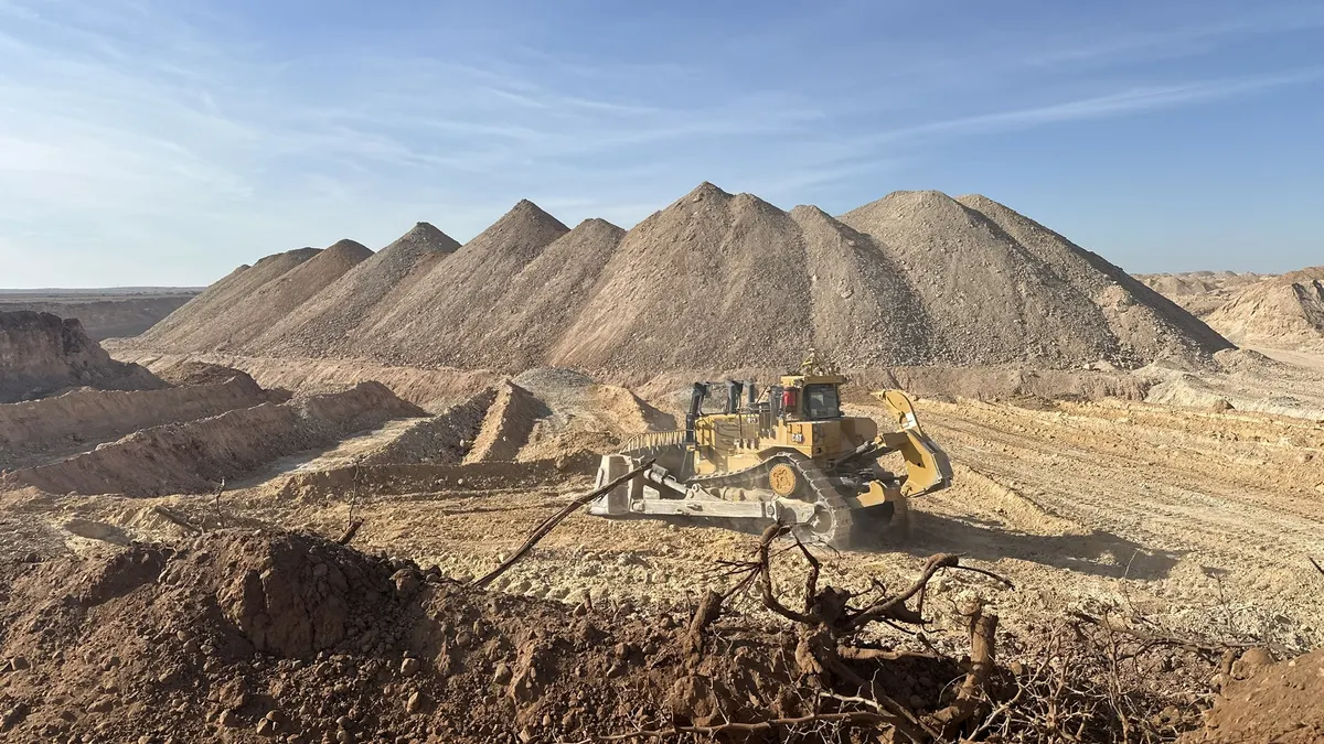 A distant view of a piece of heavy equipment on a dirt-filled scenery.