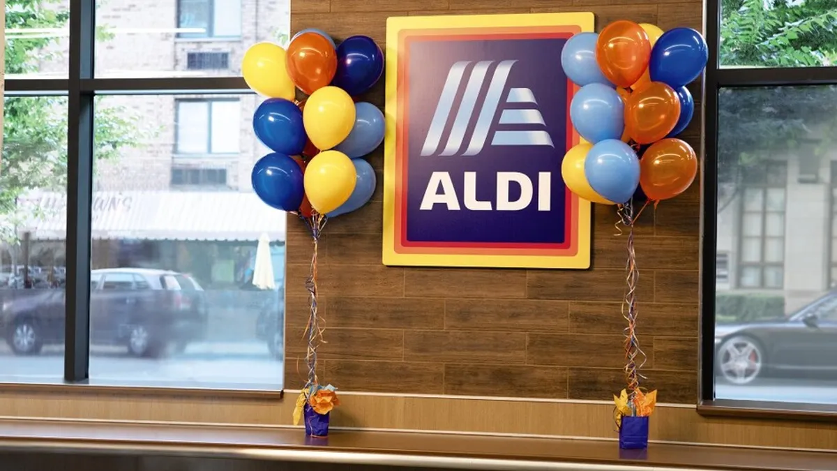 An Aldi sign inside a store flanked by multicolor balloons.