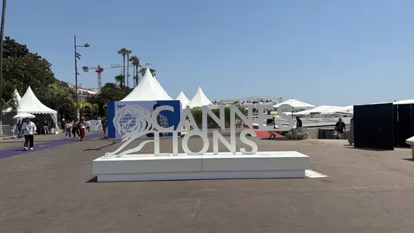 Cannes Lions signage sits on a concrete promenade on a sunny day in Cannes, France