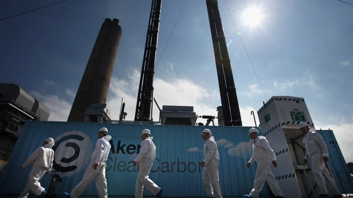 Scientists stand beside a new carbon capture test unit.