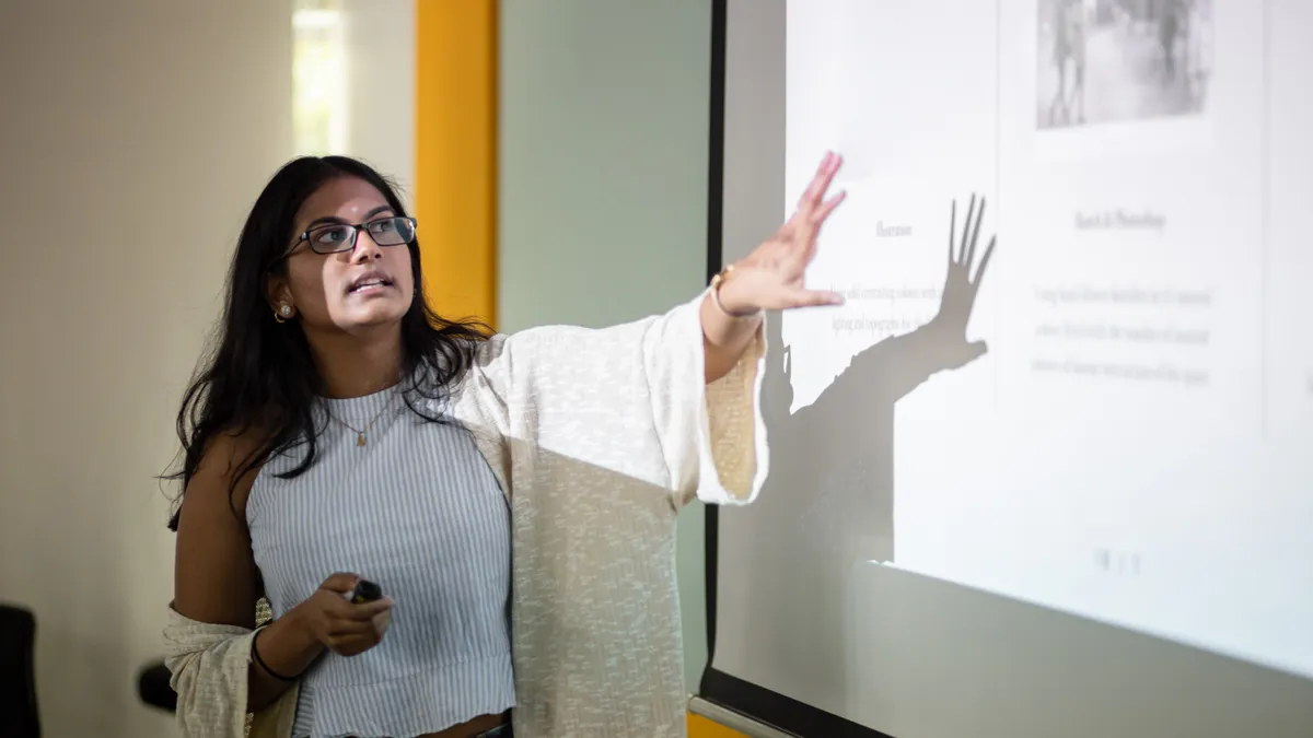 Stock photo of a presentation in front of a projection screen.