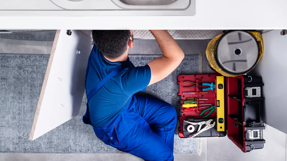 Plumber working under a sink