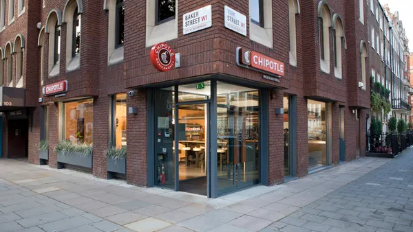 A photo of a corner of a brick building that says Chipotle on the side