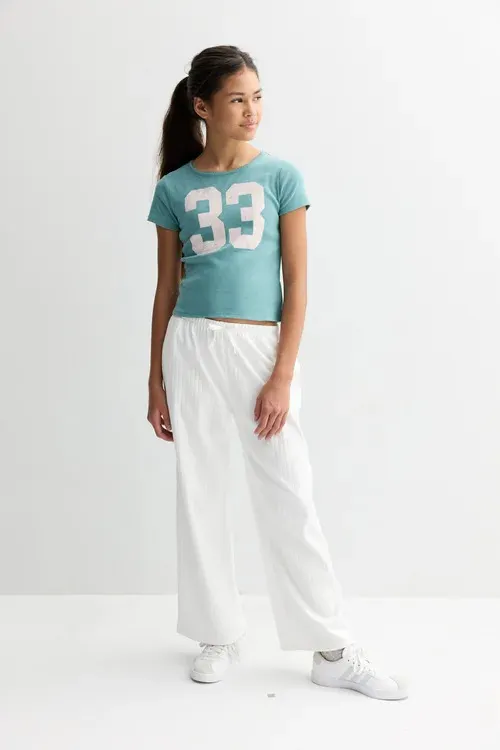 A person wearing items from Kohl's Sea + Skye private label apparel brand.