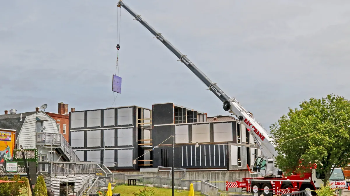 A crane lifts components onto a construction site