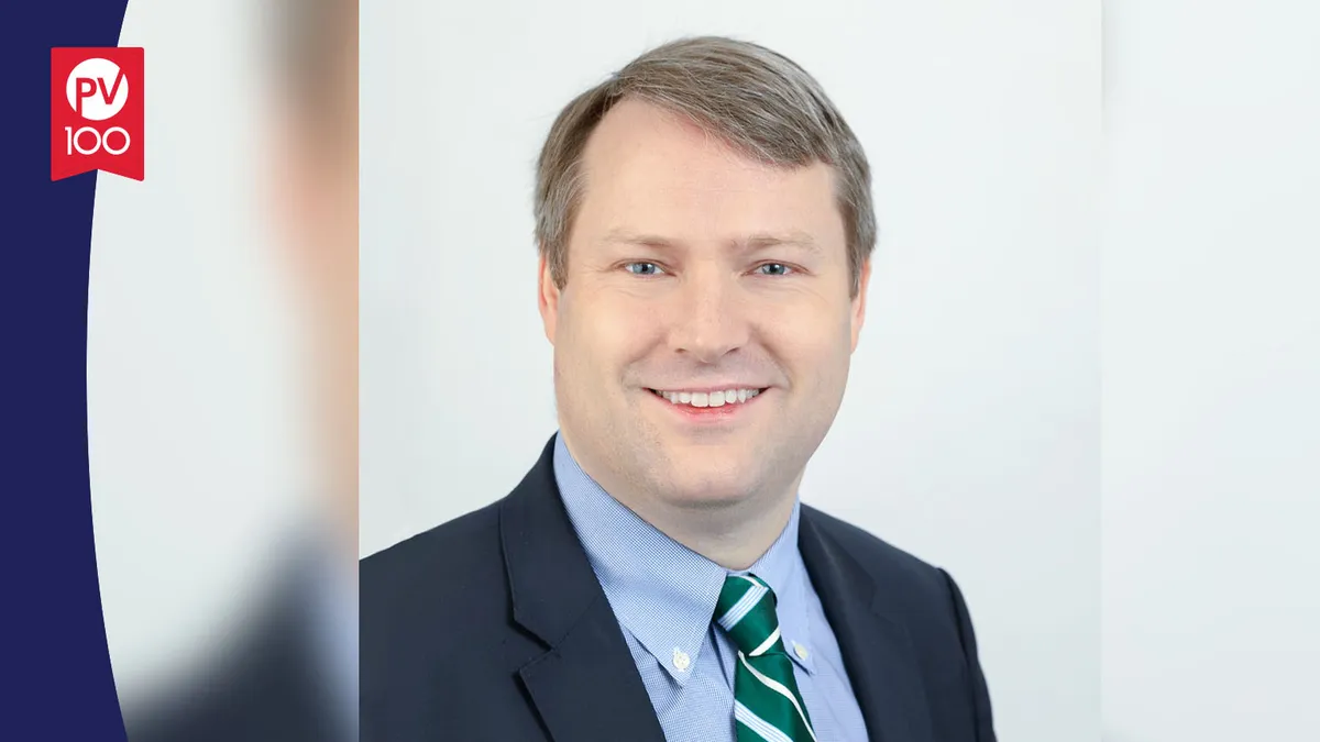 A portrait of Dr. Rich Christie framed with a banner icon that reads "PV 100"