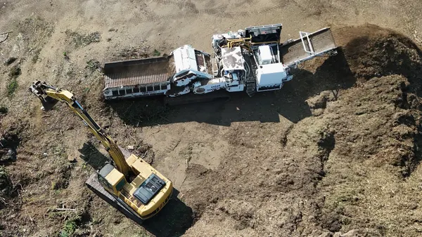 An aerial view of construction vehicles moving materials on a work site