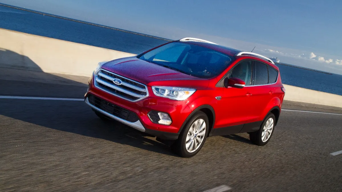 A red 2017 Ford Escape Titanium SUV on a road near a beach.