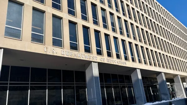 The exterior of a white stone building with windows is shown. The words U.S. Department of Education is on the side of the building.