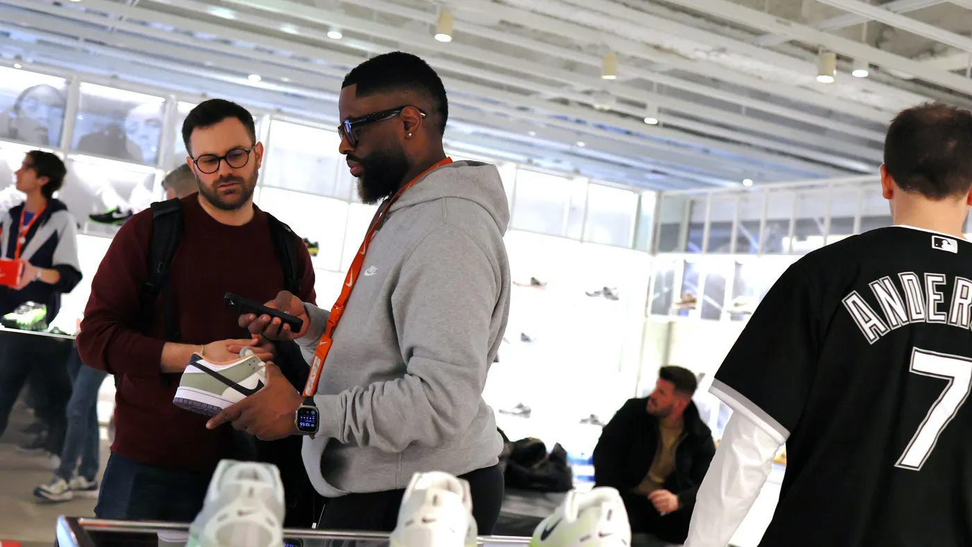 Employees and customers are seen in a retail store.