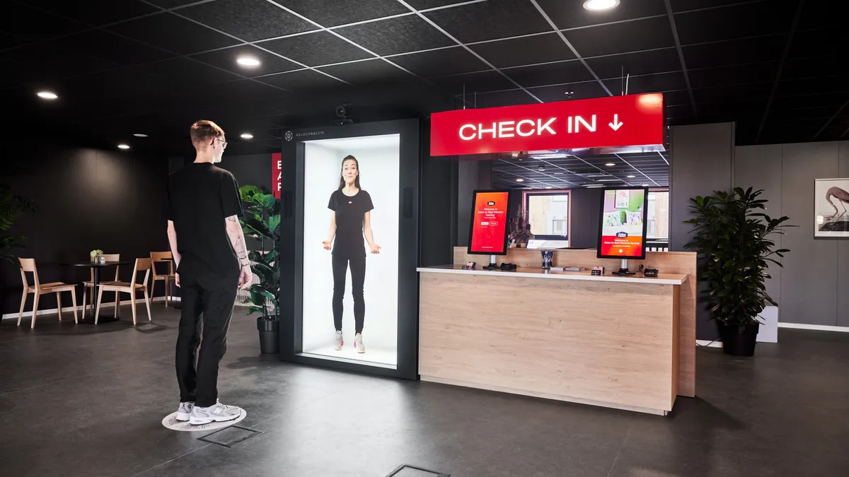 A Holoconnects "holobox" shows a hologram receptionist.