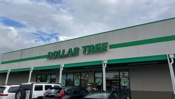 A Dollar Tree storefront with parked cars and blue skies