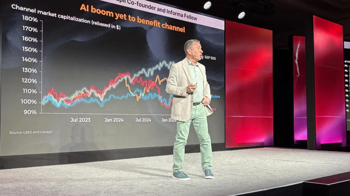 A man stands on a stage giving a keynote presentation. The digital graphic behind him shows the market capitalizations of the S&P 500, distributors and channel partners. Over the last three years.