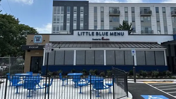 A photograph of a beige building with blue signage that says Little Blue Menu