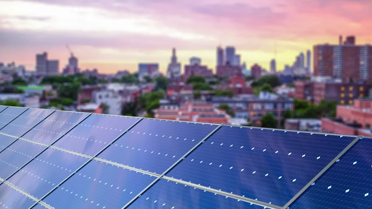 Close up of solar panels with city skyline background