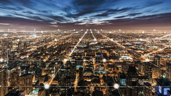 Aerial view of city buildings and lights at night.