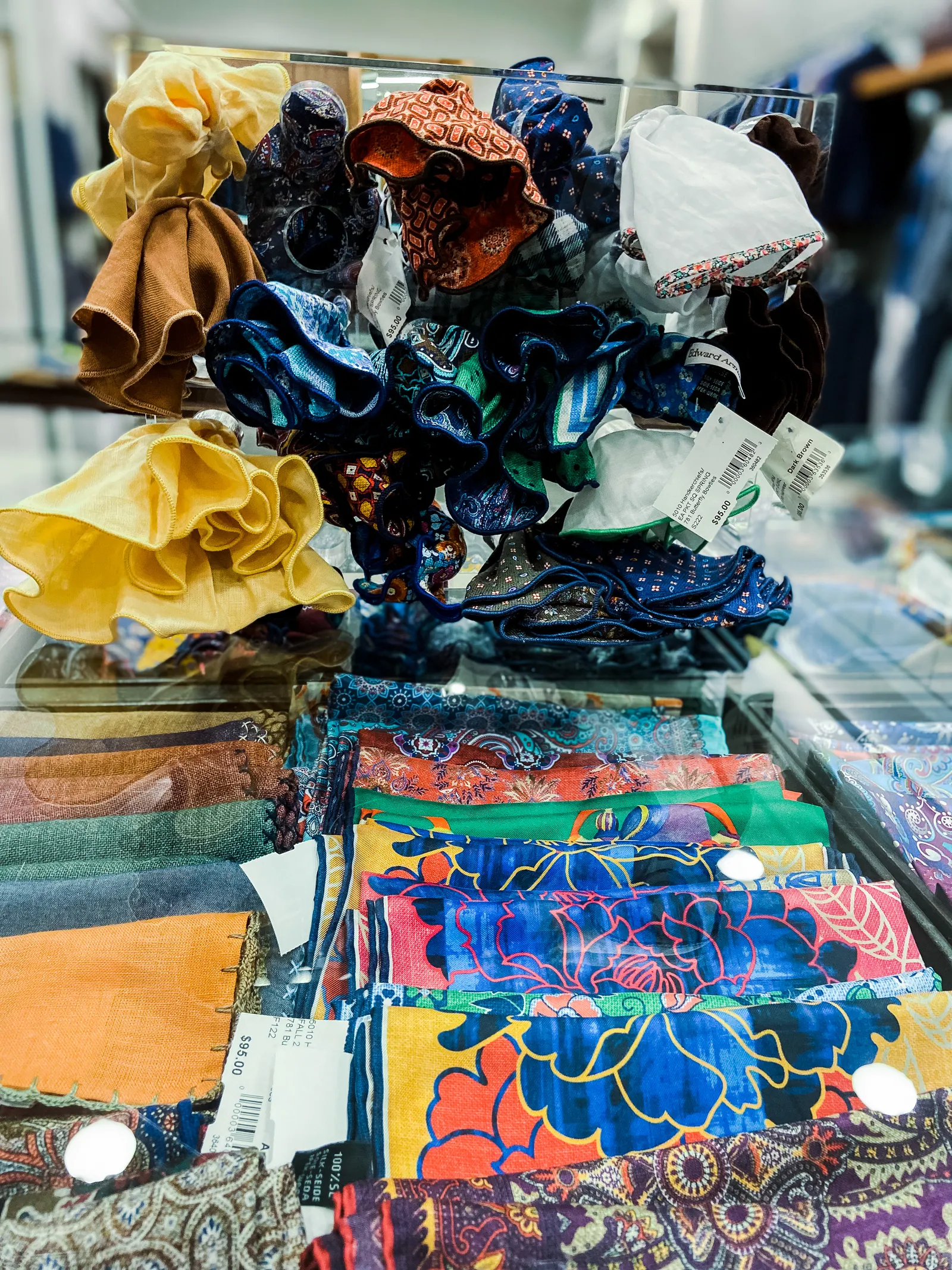 A closeup of silk ties and pocket squares in various colors and patterns.