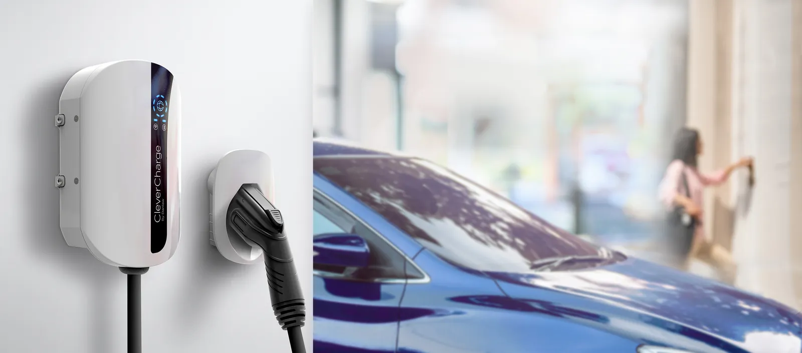 An electric vehicle charger on a wall, next to a car.