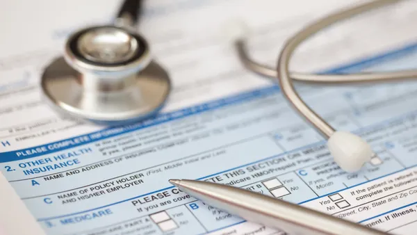 A stethoscope rests on top of a patient insurance form.