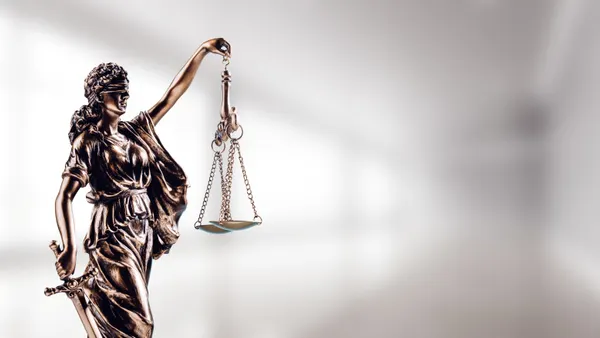 Statute holding scales of justice and a sword