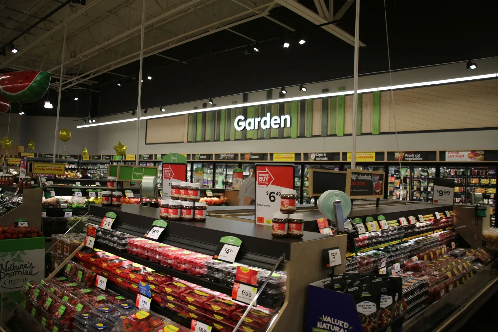 Inside a grocery store, looking at the produce section