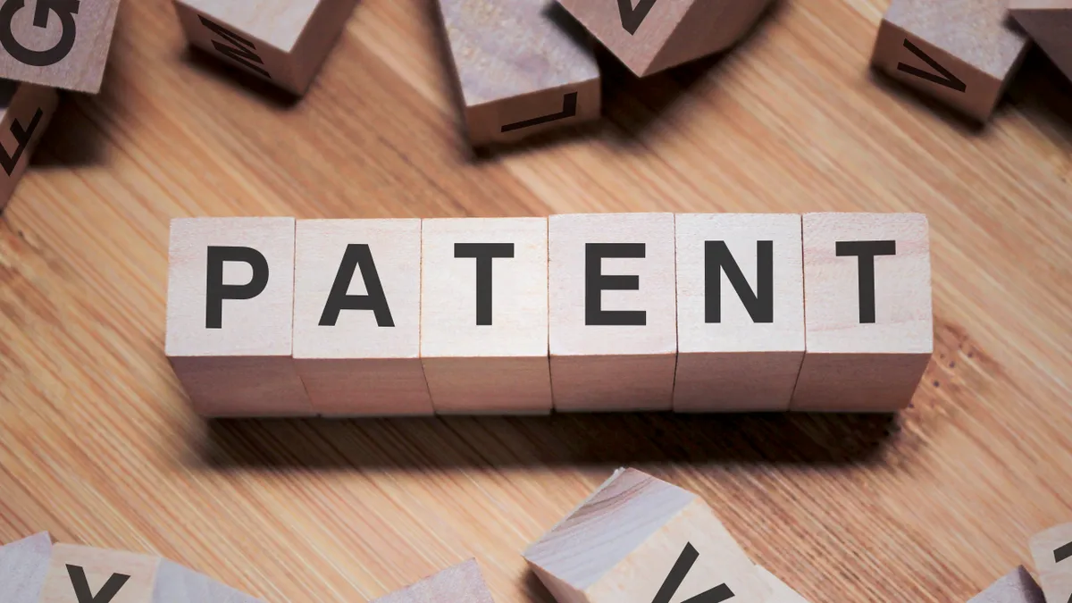 Wooden cubes spell out the word "patent"