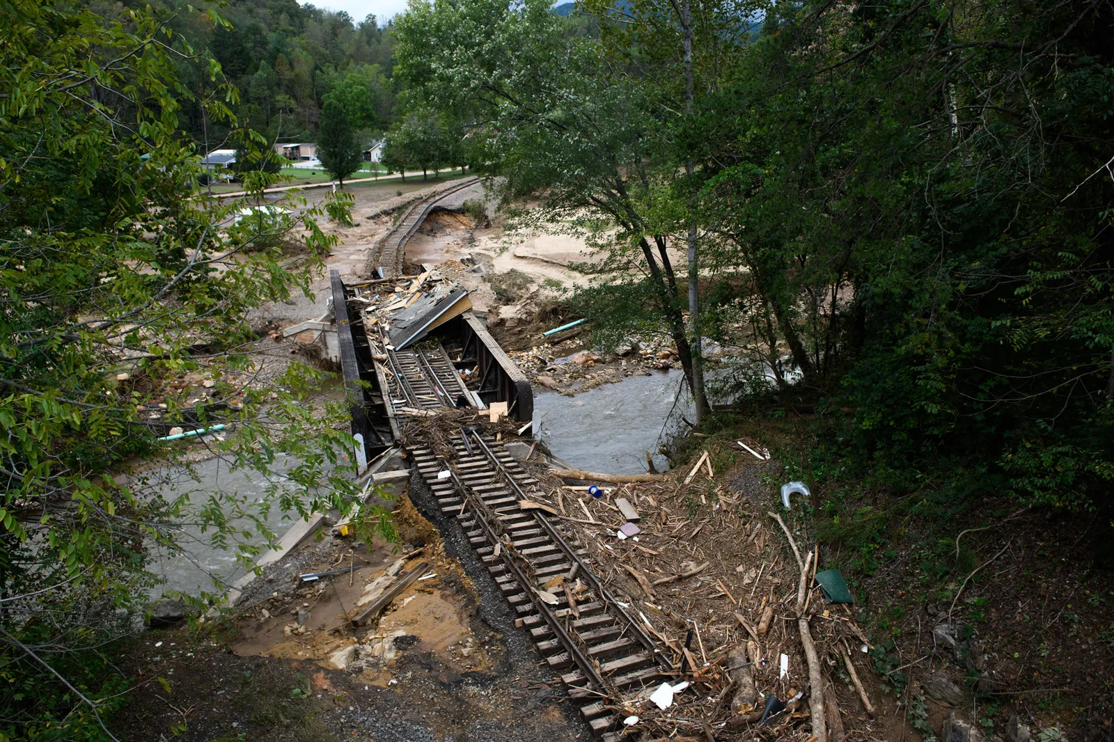 An image of destroyed train tracks running over a damaged bridge in Old Fort, North Carolina, following Hurricane Helene.