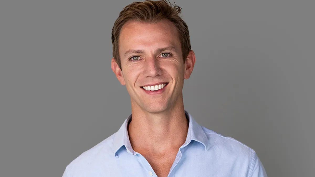 A person smiles and poses for a professional photo.