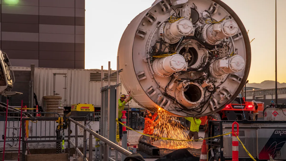 Workers cut the storage rack from the base of the drill head  as the Boring Company prepares to lower the drill head for the People Mover tunnel which will connect convention halls as part of the LVCC