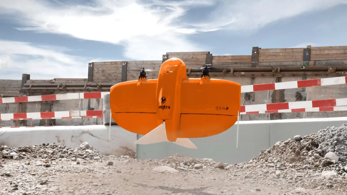 An orange drone with propellers on the top takes off.