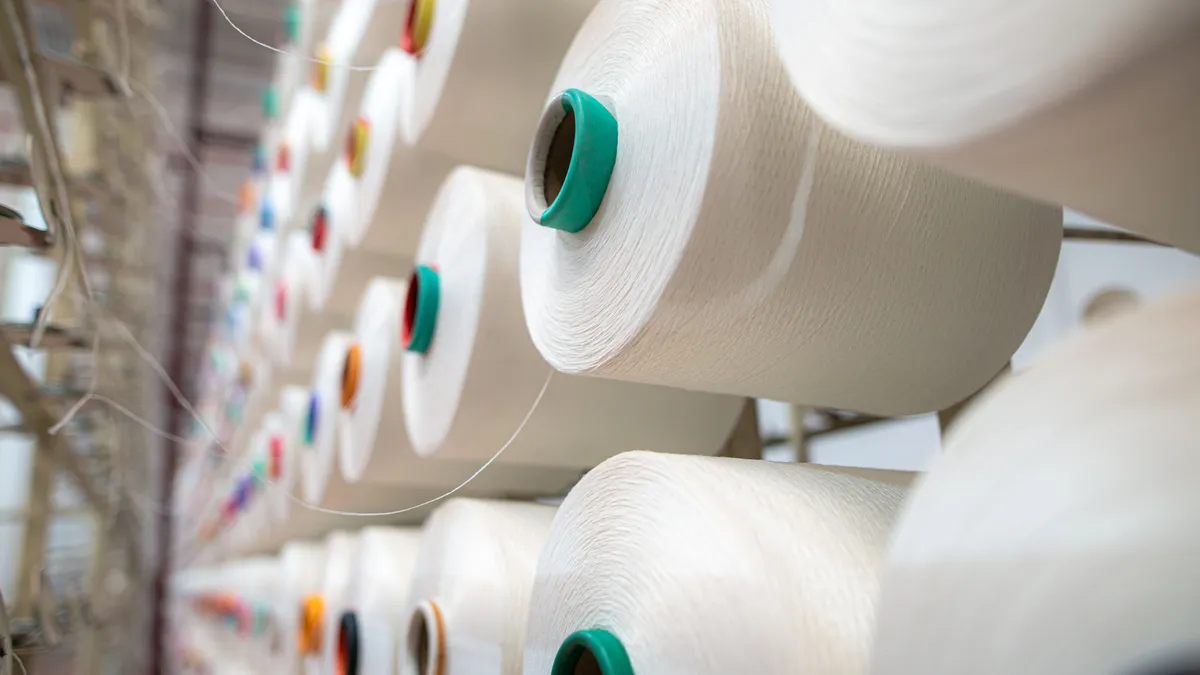 A close up of spools of yarn in a factory like setting.