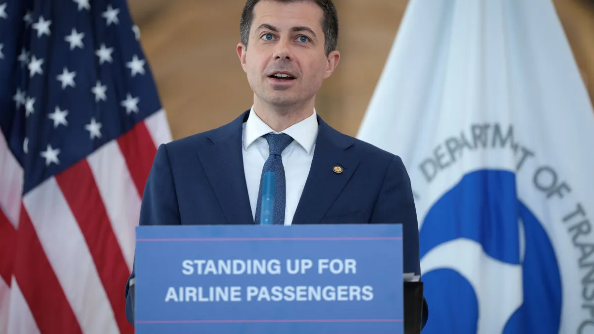 A man stands at a podium in front of a sign that reads, "Standing up for airline passengers."